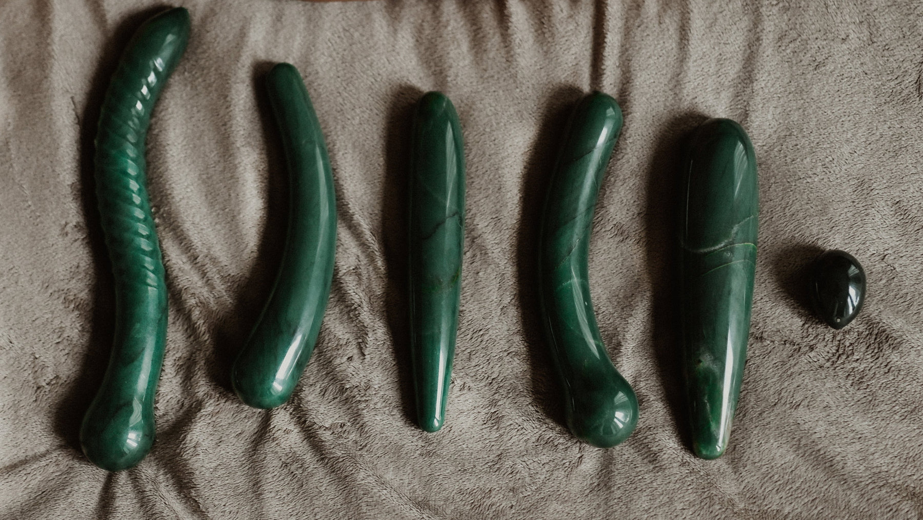 Green crystal toys on a beige surface with a blurred background