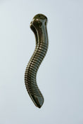 Load image into Gallery viewer, Metallic gold snake-shaped object on a light gray background