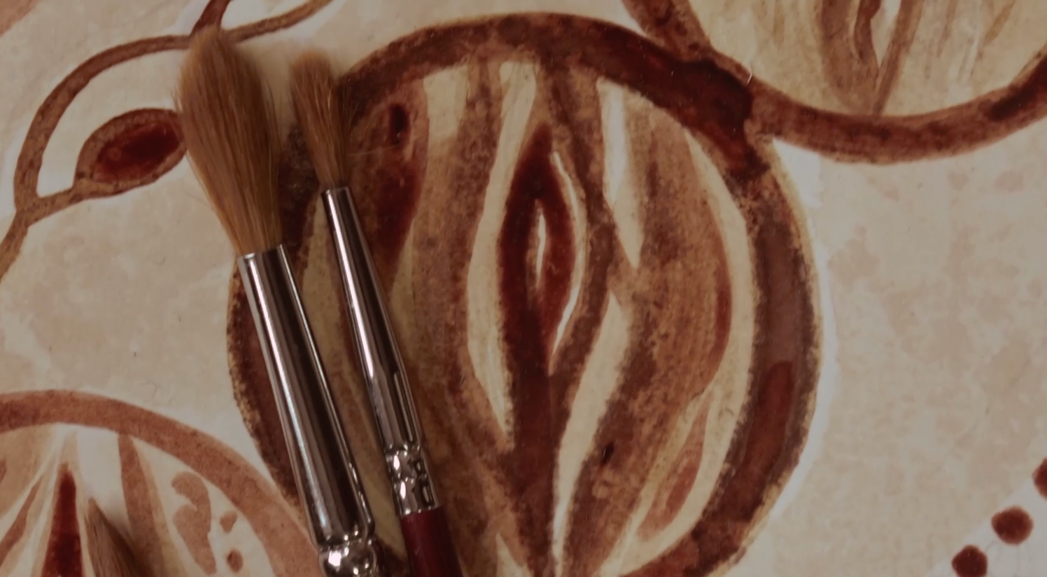 Makeup brushes on a decorative surface with intricate patterns